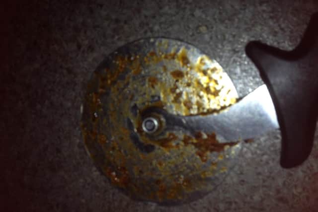 A pizza cutter covered in grease.