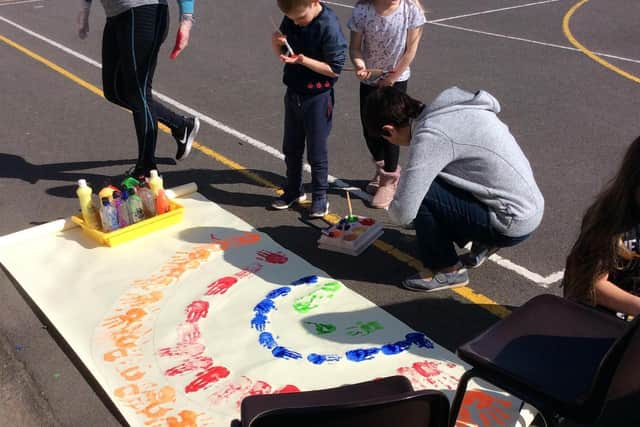 Staff teams  looking after the key worker children f have been creating a large rainbow for the outside of the school.