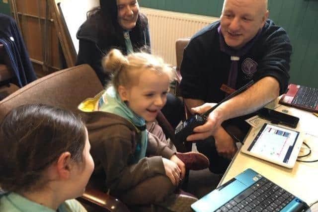 Scout leader at radio station with one of the Brownies.