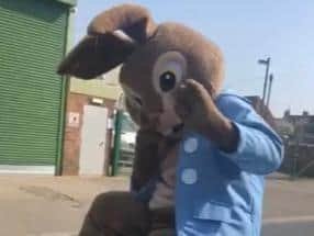 The Easter bunny waving to families along the route.
