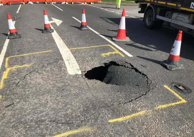 The hole beneath this road collapse is eight feet deep, say police.