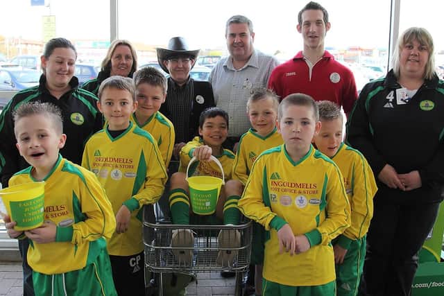Pictured: adults, from left: Jody Perry, Caz Wakefield, Lynn Clague (Tesco department manager), Ian Black (Tesco store manager), Mike Bates and Elaine Smith; boys (leftside, from front): Toby Bell, Callum Perry, Cory Streeton, Tyler Smith (in trolley), (rightside, from front) Kieran North-Longstaff, Lewis Smith, and Ellis Osbourne.