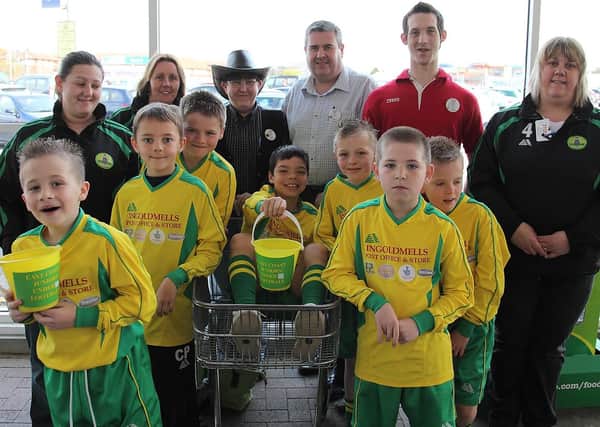 Pictured: adults, from left: Jody Perry, Caz Wakefield, Lynn Clague (Tesco department manager), Ian Black (Tesco store manager), Mike Bates and Elaine Smith; boys (leftside, from front): Toby Bell, Callum Perry, Cory Streeton,  Tyler Smith (in trolley), (rightside, from front) Kieran North-Longstaff, Lewis Smith, and Ellis Osbourne.