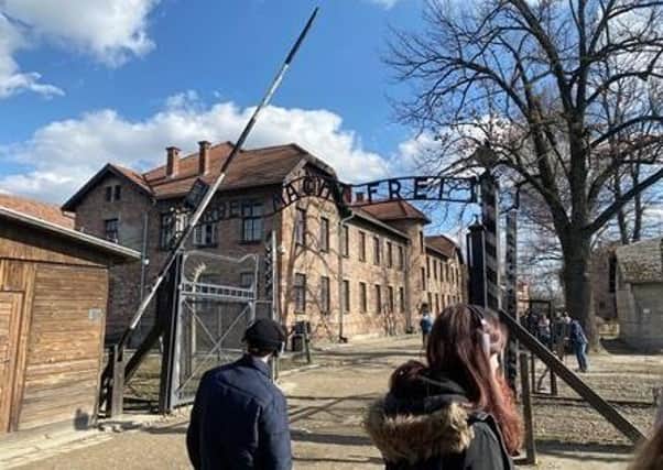 At the gates to Auschwitz Camp 2, bearing the words: Arbeit Macht Frei. EMN-200430-185810001