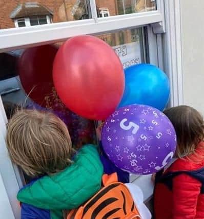 Oliver and Freya looking at a birthday message with balloons. EMN-200505-175743001