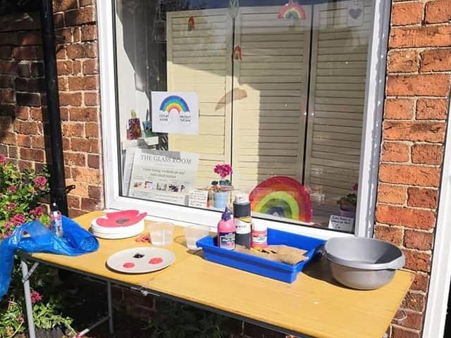 Liz Pearson's table full of materials outside The Glass Room for villagers wanting to create clay poppies for VE Day. EMN-200605-153016001