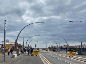Families enjoying a walk on the seafront.