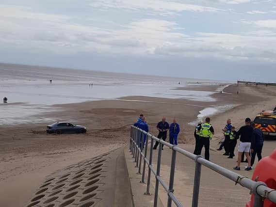 Emergency services at the scene of a car stuck on the beach in Skegness.