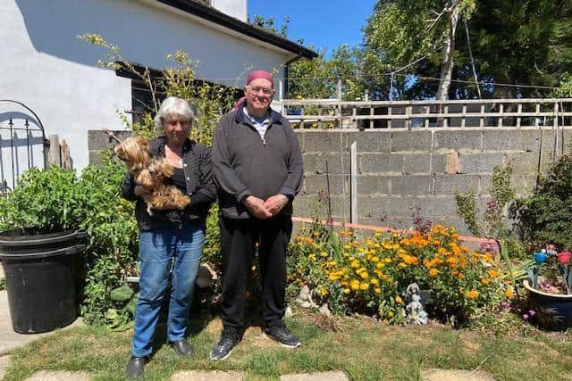 Derek and June Driver in the garden which is blooming again in spite of the floods.