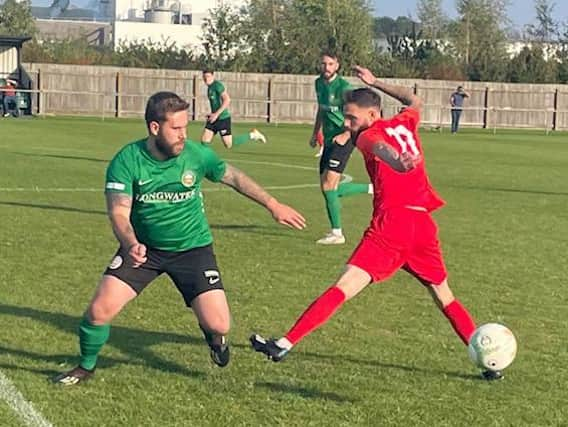 Sleaford's Joe Braithwaite looks to get past Melton Paul Anderson.