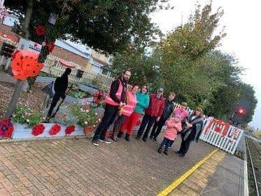 Poppies decorating the Sleaford station allotment, along with some of the adopters from Rainbow Stars. EMN-211111-152449001