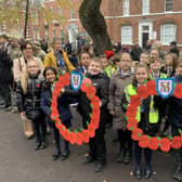 Primary school children at the service with special poppy wreaths they had made.