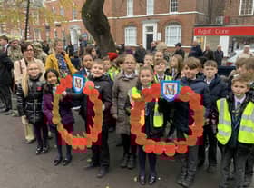 Primary school children at the service with special poppy wreaths they had made.