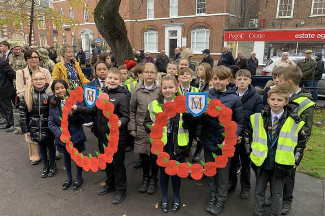 Primary school children at the service with special poppy wreaths they had made.