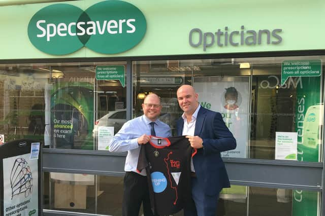 Martyn Dobson, CEO Lincolnshire Cricket (right), presenting James Coleman, store director at Specsavers Sleaford, with a Run Top 2 Bottom t-shirt that displays a graphic of the 100-mile Lincolnshire leg of the challenge from Barton on Humber to Stamford Town.