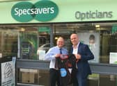 Martyn Dobson, CEO Lincolnshire Cricket (right), presenting James Coleman, store director at Specsavers Sleaford, with a Run Top 2 Bottom t-shirt that displays a graphic of the 100-mile Lincolnshire leg of the challenge from Barton on Humber to Stamford Town.