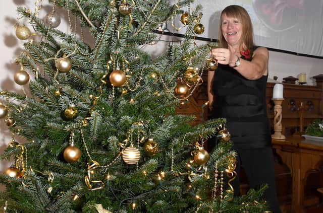 Carole Harbon decorating the Christmas tree donated by Bell's of Bennington for the Wainfleet Methodist Church Christmas Tree Festival and the Christmas Community Feast.
