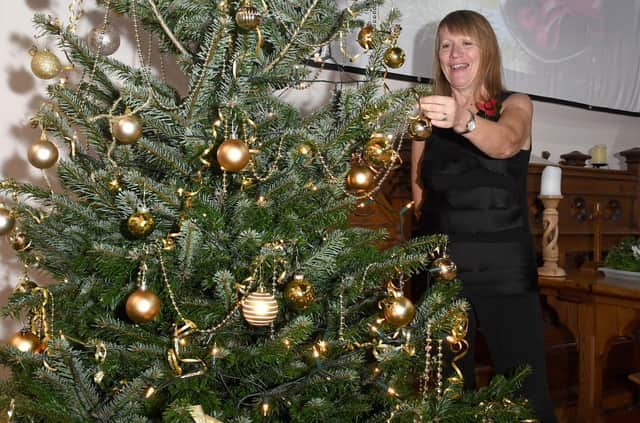 Carole Harbon decorating the Christmas tree donated by Bell's of Bennington for the Wainfleet Methodist Church Christmas Tree Festival and the  Christmas Community Feast.