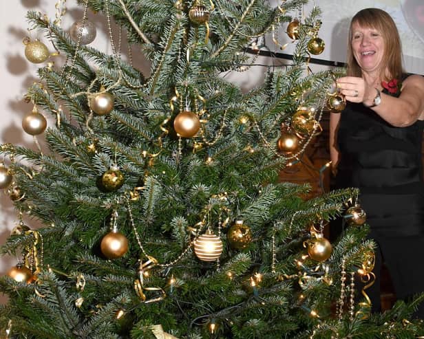 Carole Harbon decorating the Christmas tree donated by Bell's of Bennington for the Wainfleet Methodist Church Christmas Tree Festival and the  Christmas Community Feast.