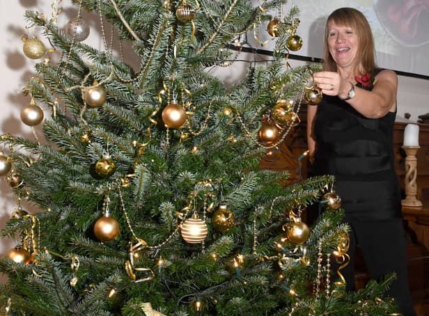 Carole Harbon decorating the Christmas tree donated by Bell's of Bennington for the Wainfleet Methodist Church Christmas Tree Festival and the  Christmas Community Feast.