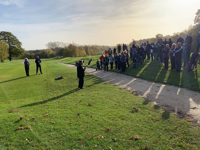 A crowd watches the captains drive in.