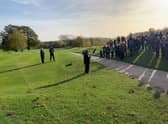 A crowd watches the captains drive in.