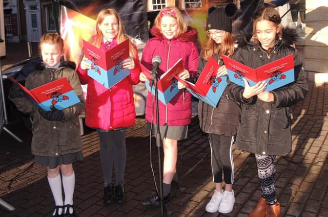 William Alvey School pupils recite Christmas poems for market-goers. EMN-210612-152327001