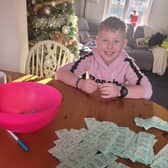 Ethan with all the raffle tickets sold, doing the prize draw. EMN-210912-095703001