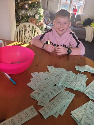 Ethan with all the raffle tickets sold, doing the prize draw. EMN-210912-095703001