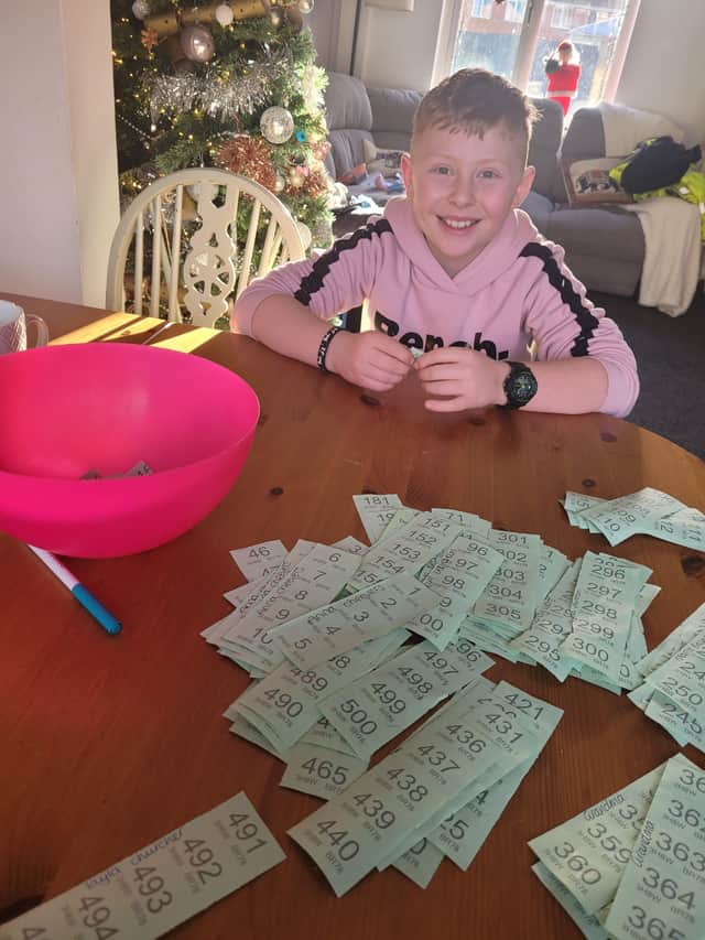 Ethan with all the raffle tickets sold, doing the prize draw. EMN-210912-095703001