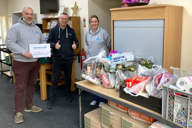Monty Cordingley, Aftersales Manager (left), and Hannah Ross, Spares Manager (right), from Grunwald UK, delivering donated groceries to Rod Munro, NLCL Team Leader (middle), at the New Life Community Larder in Sleaford. EMN-211220-164900001