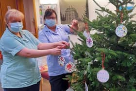 Staff at the Sue Ryder Thorpe Hall Hospice hanging the baubles. EMN-211222-140109001