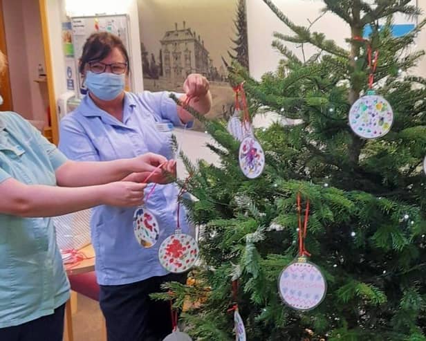 Staff at the Sue Ryder Thorpe Hall Hospice hanging the baubles. EMN-211222-140109001