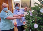 Staff at the Sue Ryder Thorpe Hall Hospice hanging the baubles. EMN-211222-140109001