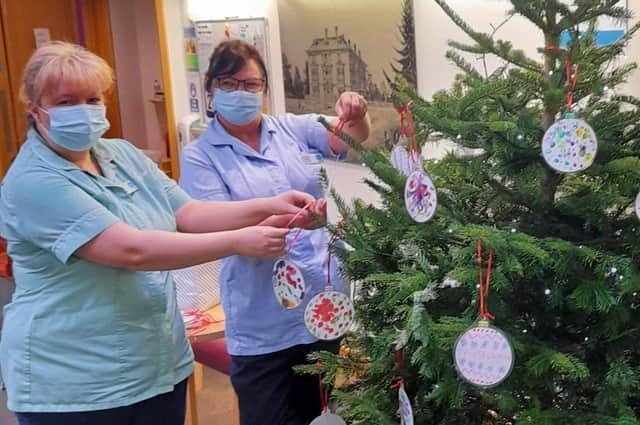 Staff at the Sue Ryder Thorpe Hall Hospice hanging the baubles. EMN-211222-140109001