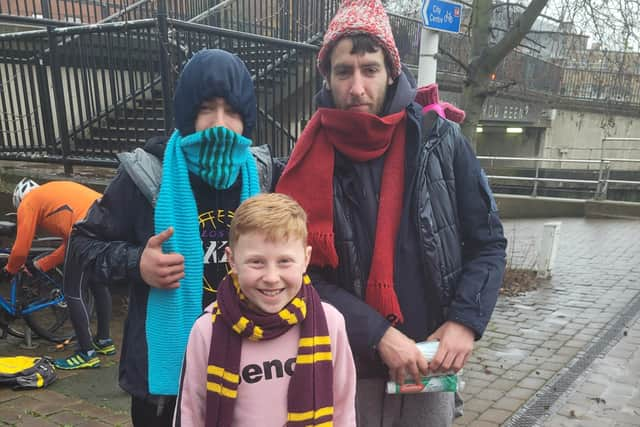 Ethan Kay stops to pose for a photo with some of the homeless men in Lincoln that he delivered care packages to. EMN-211230-183020001