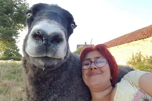 Amanda cuddling up with one of her sheep - all have names. EMN-220701-155753001