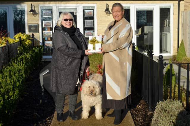 Helene Key, Sales Manager at Chestnut Homes (Right), handing over the iPad to competition winner, Joanna Haselwood, with her pet labradoodle, Lily EMN-220116-214655001