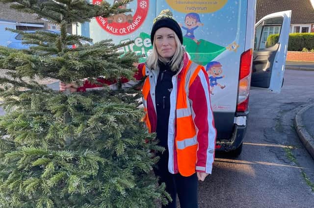 Louise Cotton, Fundraising Officer busy collecting Christmas trees to recycle. EMN-220117-171713001