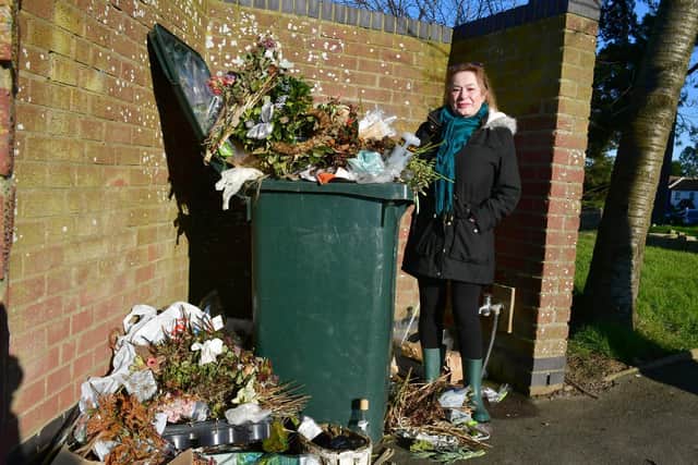 Pamela Ellis by the overflowing bins in St Mary's Churchyard.
