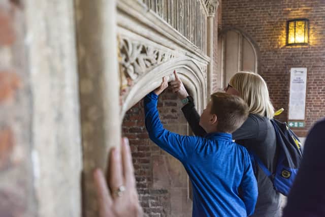 Visitors taking a closer look at one of the large fireplaces at Tattershall Castle, Lincolnshire EMN-220126-125442001