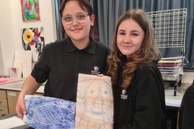 Scarlett Stanley (left) and Nicole Meese produce prints of animals in their art lesson.