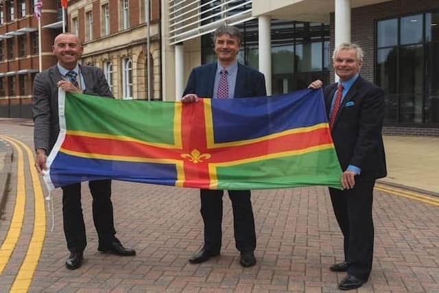 From left, Coun Rob Waltham, leader of North Lincolnshire Council; Coun Phillip Jackson, leader of North East Lincolnshire Council; and Coun Martin Hill, leader of Lincolnshire County Council, pictured with the Lincolnshire flag. EMN-220202-135544001