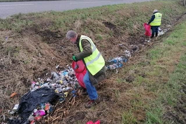 The group's volunteers tackle a fly-tip in a roadside ditch. Image supplied