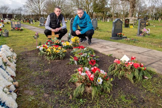 Luke and Ben Robinson at the grave next to where their father is buried which had been bought for their mother and mistakenly sold.