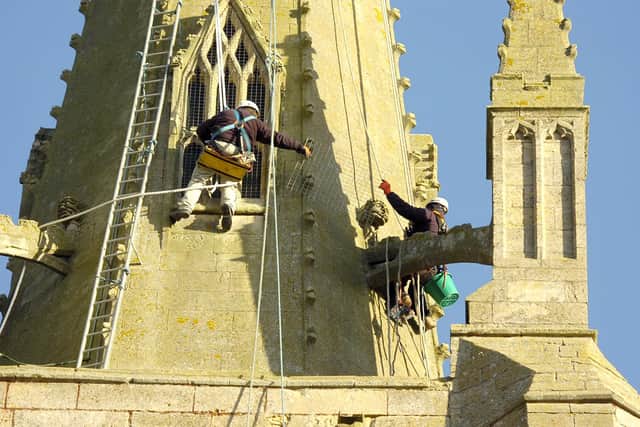 Steeple jacks working on Helpringham Church spire to fix pinnacles after storm damage.