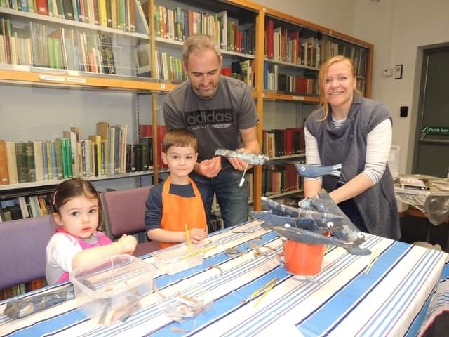Fish making workshop leader and artist Ruth Pigott guides Will Titchband and his children Darcie, three, and Oscar, five, of Sleaford. EMN-220215-171614001