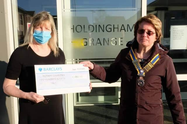 Holdingham Grange manager Hazel Whittaker presents the donation to Rotary president Cath Hamblin.