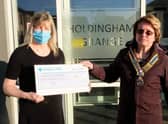Holdingham Grange manager Hazel Whittaker presents the donation to Rotary president Cath Hamblin.