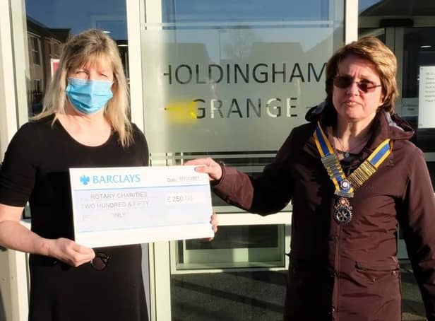 Holdingham Grange manager Hazel Whittaker presents the donation to Rotary president Cath Hamblin.